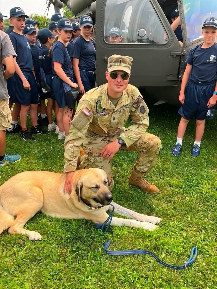 Mac, the Denville Police Department therapy K9, lying in the grass at a community event
