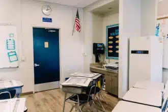 An empty school classroom with rows of student desks