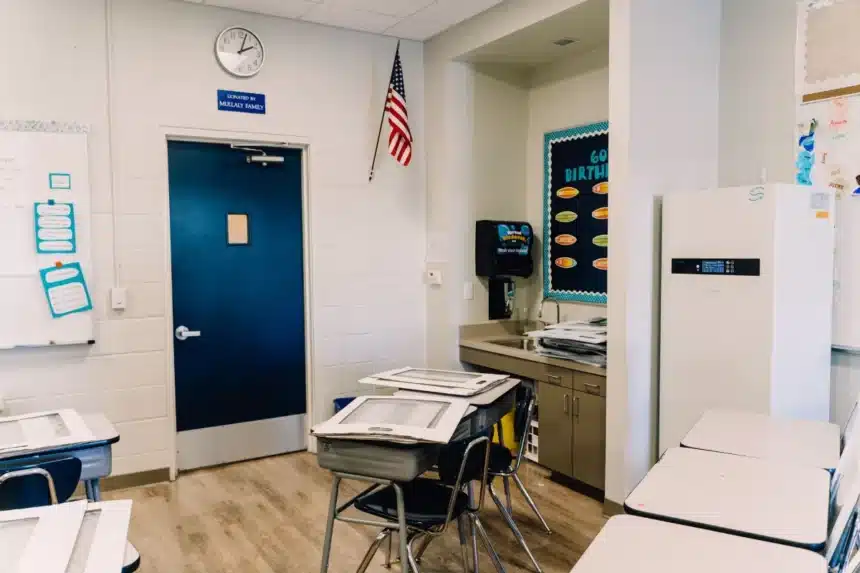 An empty school classroom with rows of student desks
