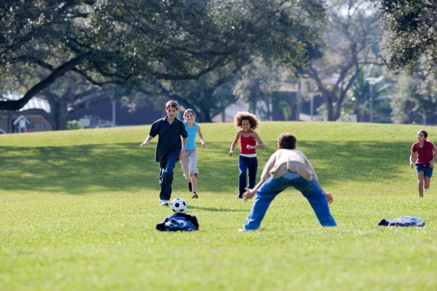 Children playing soccer on a grass field, illustrating the youth sports in Denville NJ guide