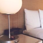 Made bed and bedside lamp in a hotel room