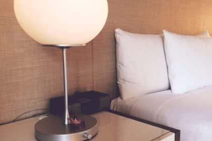Made bed and bedside lamp in a hotel room