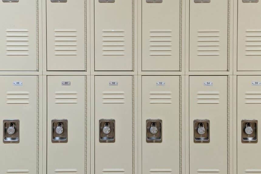 Row of beige lockers with combination locks in a school hallway